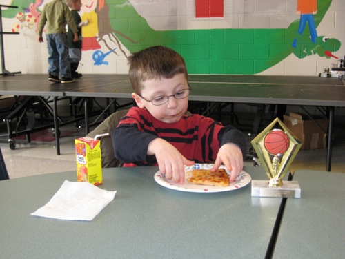 Colin eating pizza at the banquet